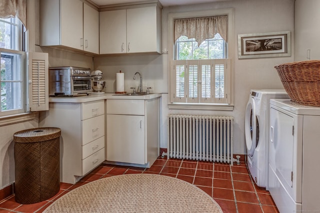 laundry area with a healthy amount of sunlight, a sink, washer and dryer, and radiator