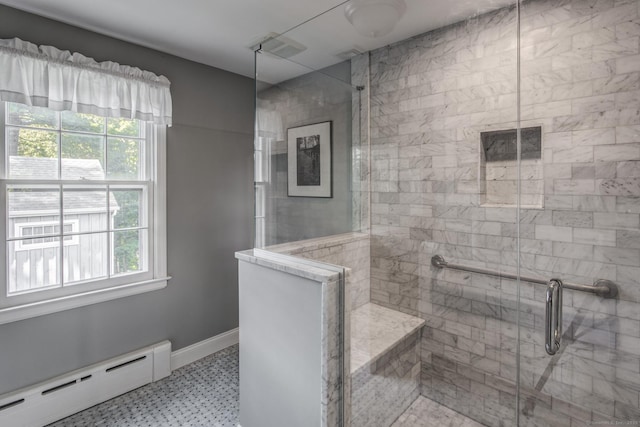 bathroom featuring a healthy amount of sunlight, baseboards, a baseboard heating unit, and a tile shower