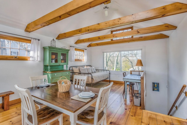 dining area with baseboards, plenty of natural light, lofted ceiling with beams, and light wood finished floors