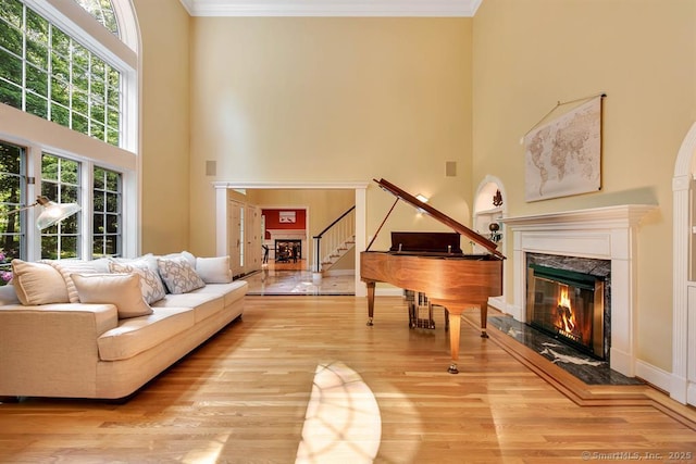 living area with ornamental molding, a fireplace, and wood finished floors