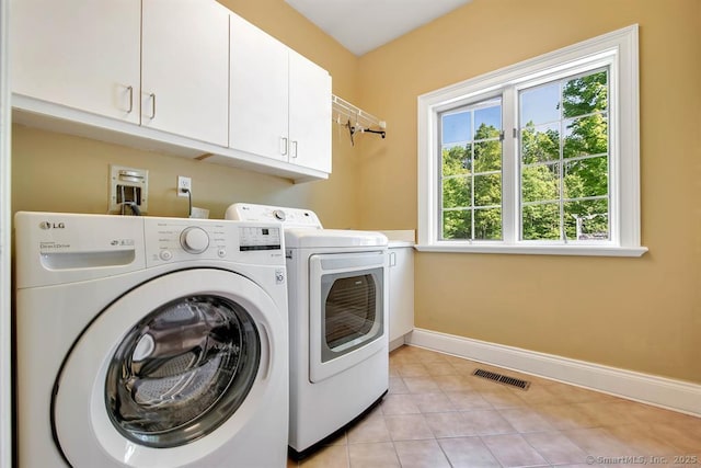 washroom featuring cabinet space, light tile patterned floors, baseboards, visible vents, and independent washer and dryer