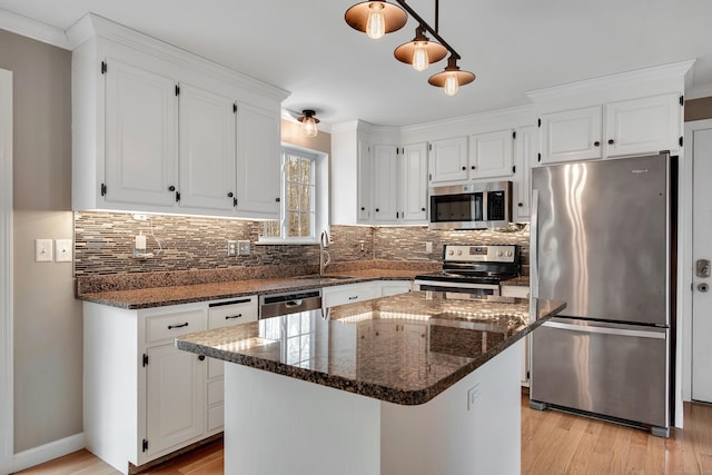 kitchen featuring stainless steel appliances, light wood-type flooring, a sink, and white cabinetry