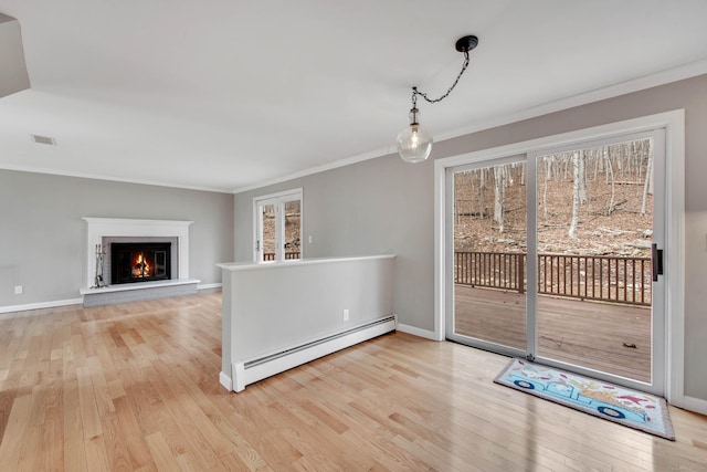 interior space with baseboards, visible vents, a baseboard radiator, crown molding, and light wood-type flooring