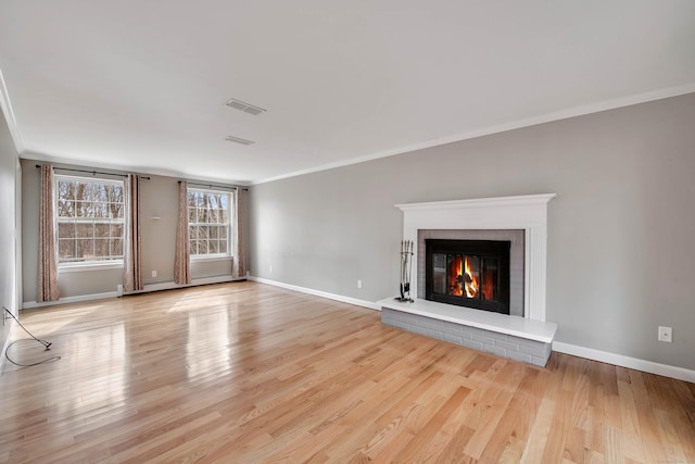 unfurnished living room featuring a brick fireplace, wood finished floors, visible vents, and crown molding