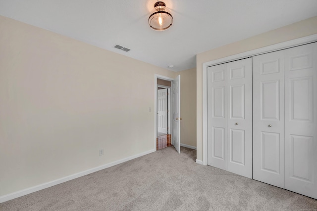 unfurnished bedroom with carpet, a closet, visible vents, and baseboards