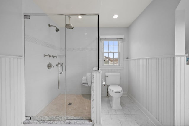 full bathroom featuring toilet, a stall shower, and wainscoting