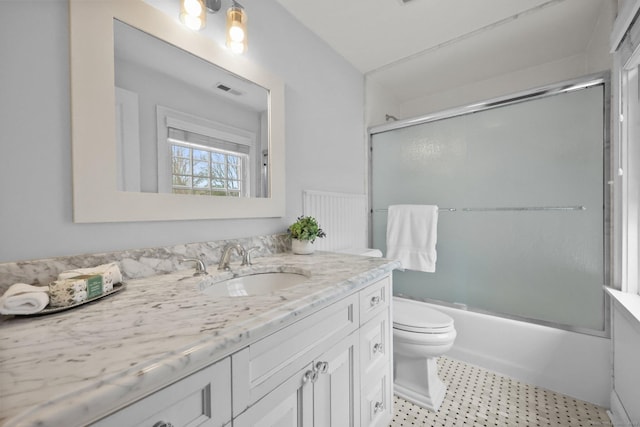 full bath featuring vanity, toilet, visible vents, and bath / shower combo with glass door