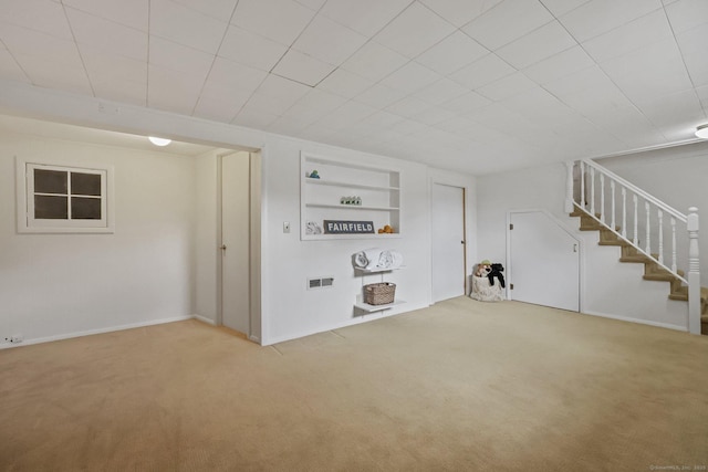 finished basement featuring stairs, built in features, and carpet