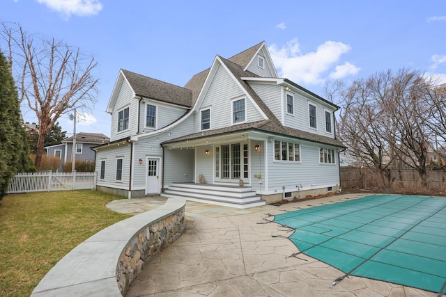 rear view of property featuring a lawn, a patio, a fenced backyard, roof with shingles, and a fenced in pool