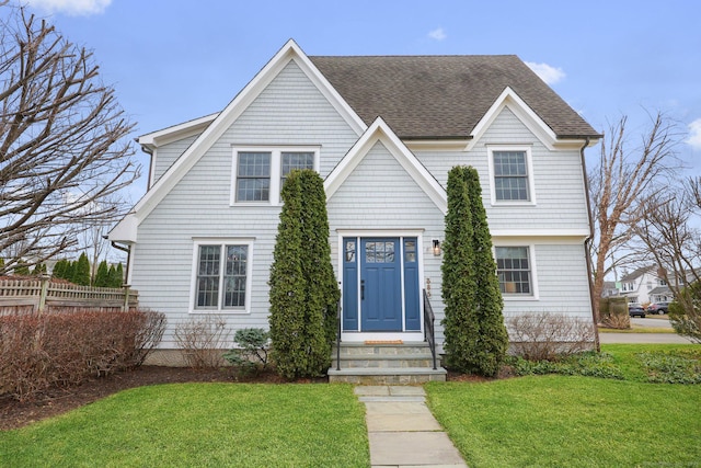 view of front of home featuring a front lawn and a shingled roof