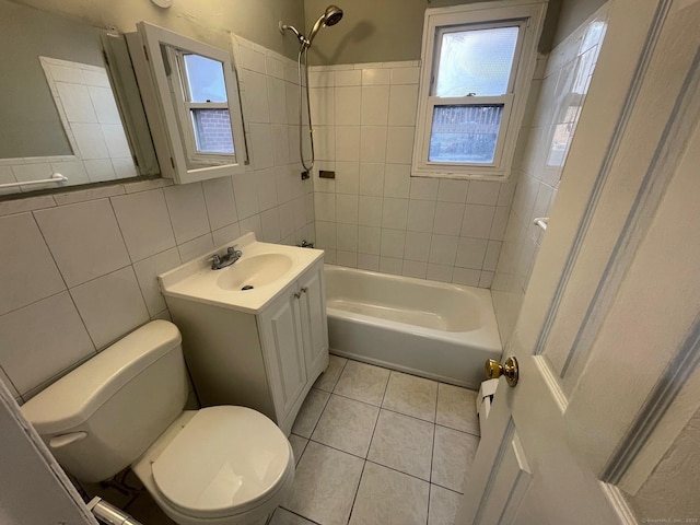 full bath with tile walls, bathtub / shower combination, toilet, vanity, and tile patterned flooring