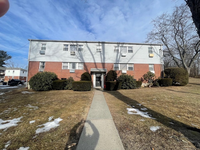 view of front of house featuring brick siding and a front yard