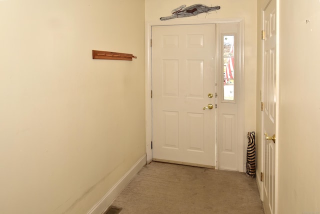 entryway with baseboards and light colored carpet