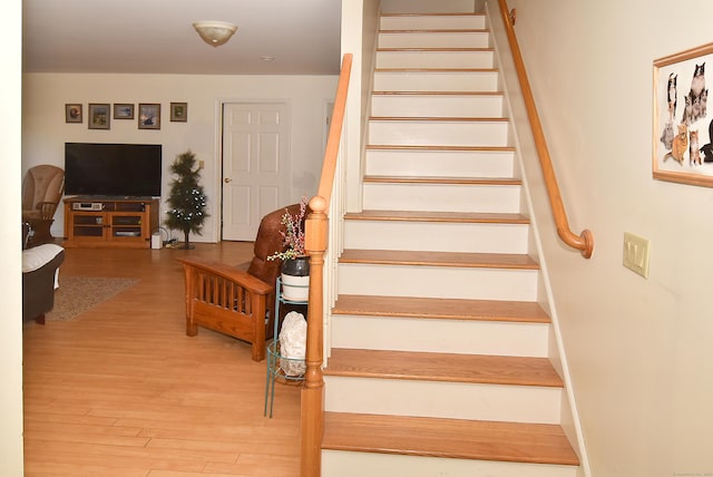 stairs featuring wood finished floors and baseboards