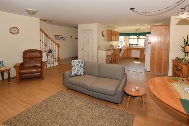 living area featuring light wood-style floors and stairway