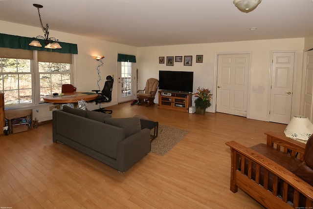 living room featuring a chandelier and light wood-type flooring