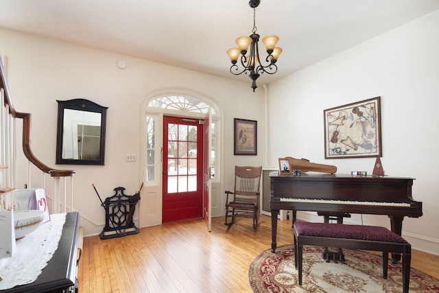 foyer featuring a notable chandelier, baseboards, and light wood-style floors