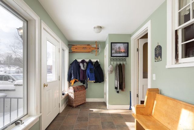 mudroom with arched walkways and baseboards