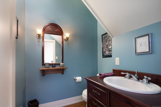 bathroom with vanity, toilet, and baseboards