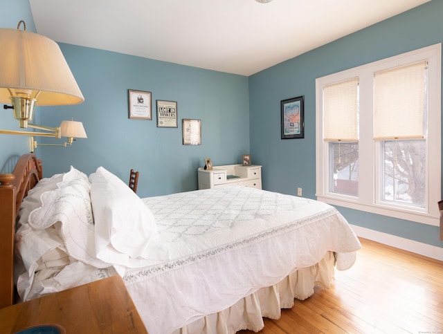 bedroom with hardwood / wood-style floors and baseboards