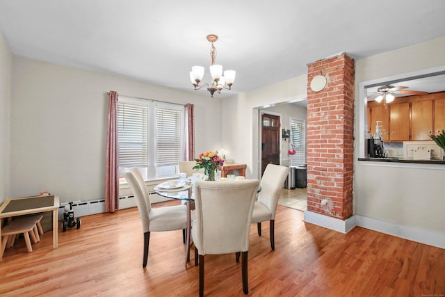 dining room with baseboards, a notable chandelier, and light wood finished floors