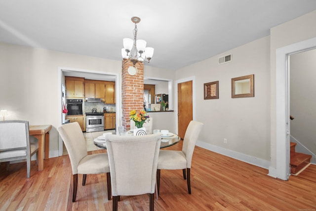 dining space with visible vents, a notable chandelier, stairway, and light wood finished floors