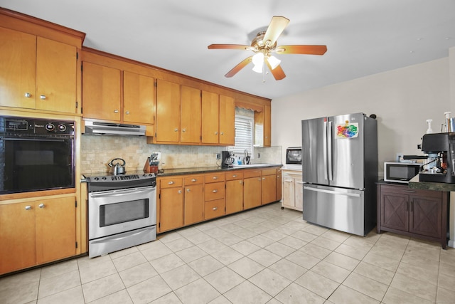 kitchen featuring brown cabinets, appliances with stainless steel finishes, decorative backsplash, and under cabinet range hood