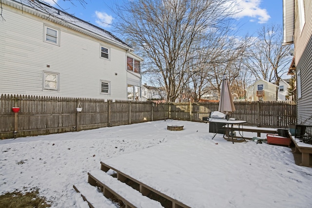 yard layered in snow featuring a fenced backyard