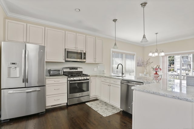 kitchen with ornamental molding, dark wood-style flooring, a peninsula, stainless steel appliances, and a sink