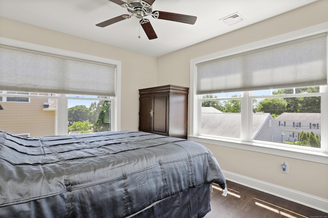 bedroom with dark wood-type flooring, visible vents, baseboards, and a ceiling fan