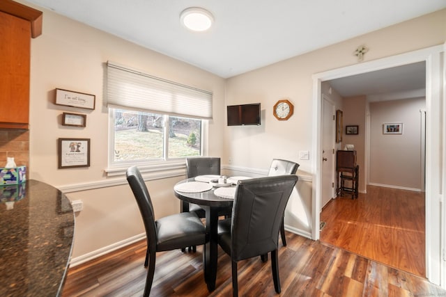 dining area with baseboards and wood finished floors