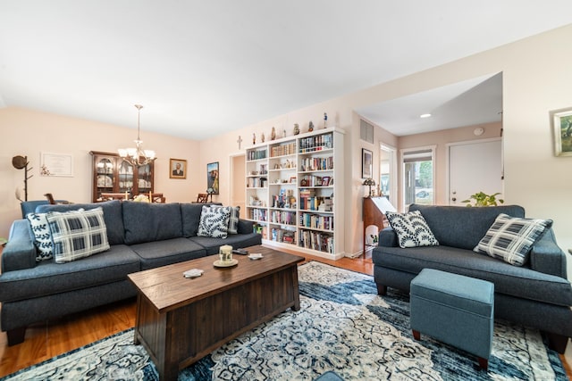 living area with visible vents, a chandelier, and wood finished floors