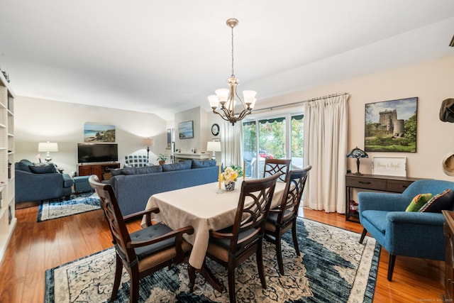 dining area with wood finished floors and an inviting chandelier