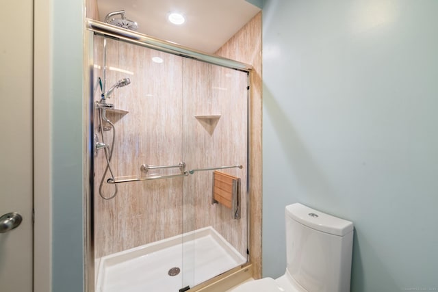 bathroom featuring toilet and a stall shower