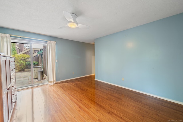 spare room with baseboards, a ceiling fan, a textured ceiling, and light wood finished floors