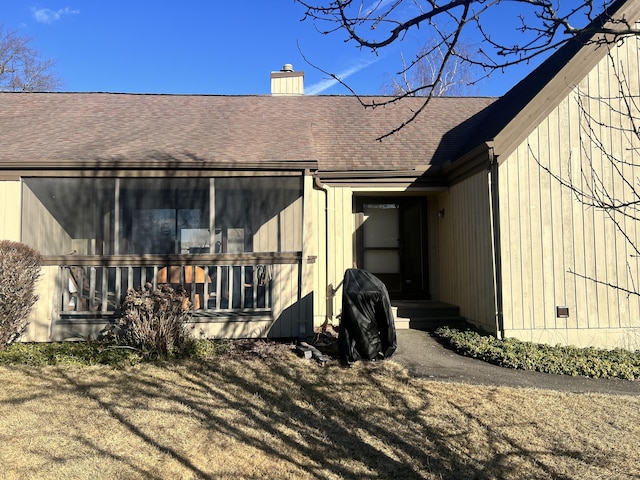 back of property featuring a shingled roof and a chimney