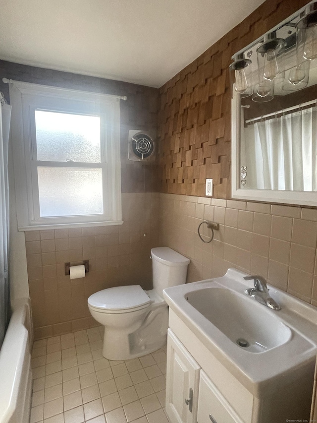 full bath featuring toilet, tile patterned floors, curtained shower, vanity, and tile walls