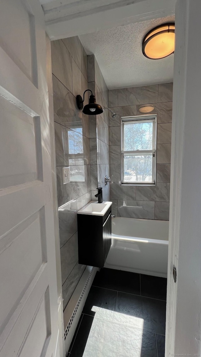 full bath featuring shower / bathtub combination, a textured ceiling, vanity, tile walls, and tile patterned floors