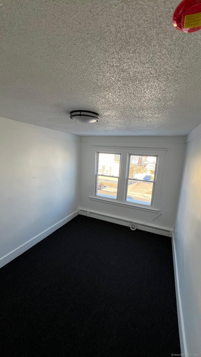 spare room featuring a textured ceiling and baseboards