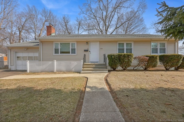 view of front of house featuring a front yard, a chimney, and an attached garage