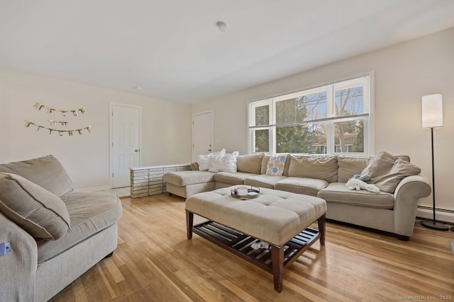 living room with light wood-style flooring and baseboard heating