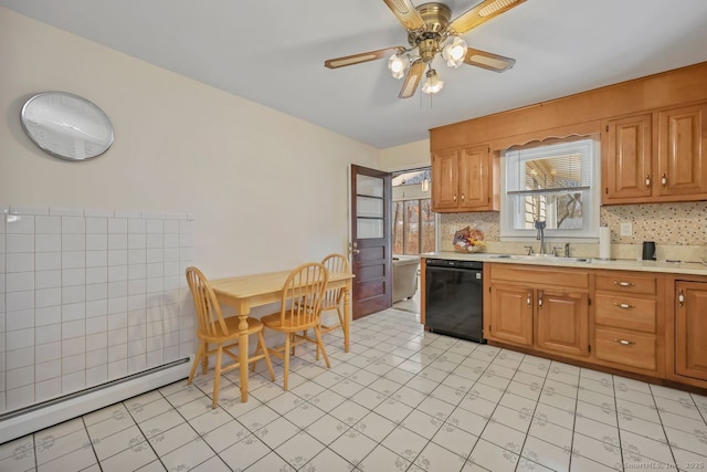 kitchen featuring black dishwasher, ceiling fan, baseboard heating, light countertops, and a sink