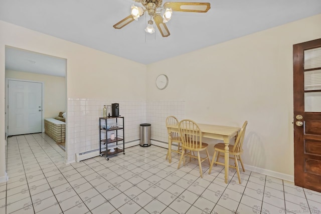 dining area featuring a baseboard radiator, a ceiling fan, and tile walls