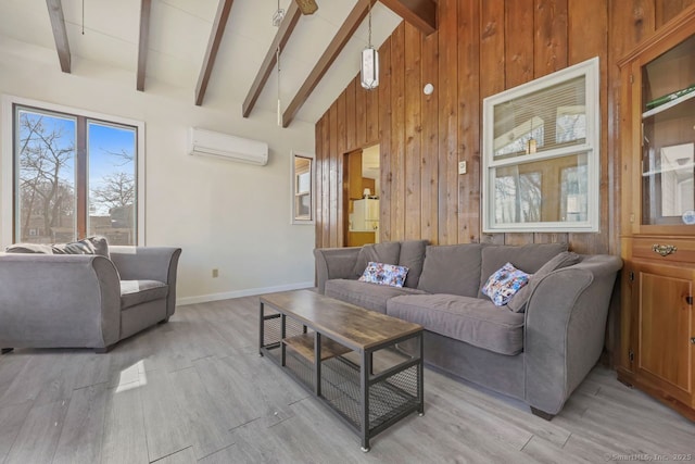 living area with beam ceiling, a wall unit AC, wooden walls, and light wood finished floors