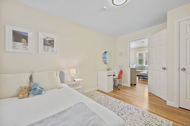 bedroom with light wood-type flooring and baseboards