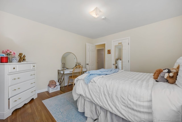 bedroom with baseboards and dark wood finished floors