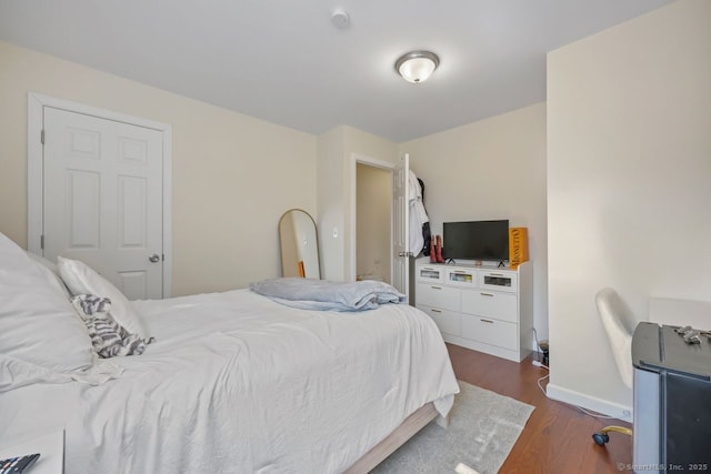 bedroom with baseboards and wood finished floors