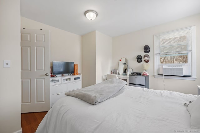 bedroom with cooling unit and wood finished floors