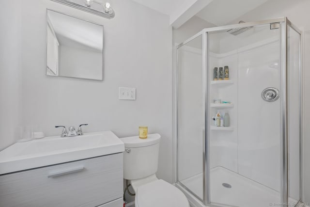 full bathroom with a stall shower, vanity, and toilet