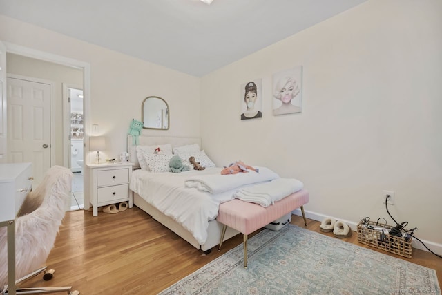 bedroom with light wood-style flooring and baseboards